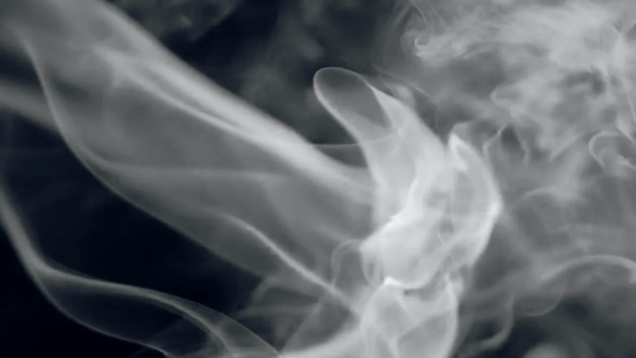 White smoke curling over a black background